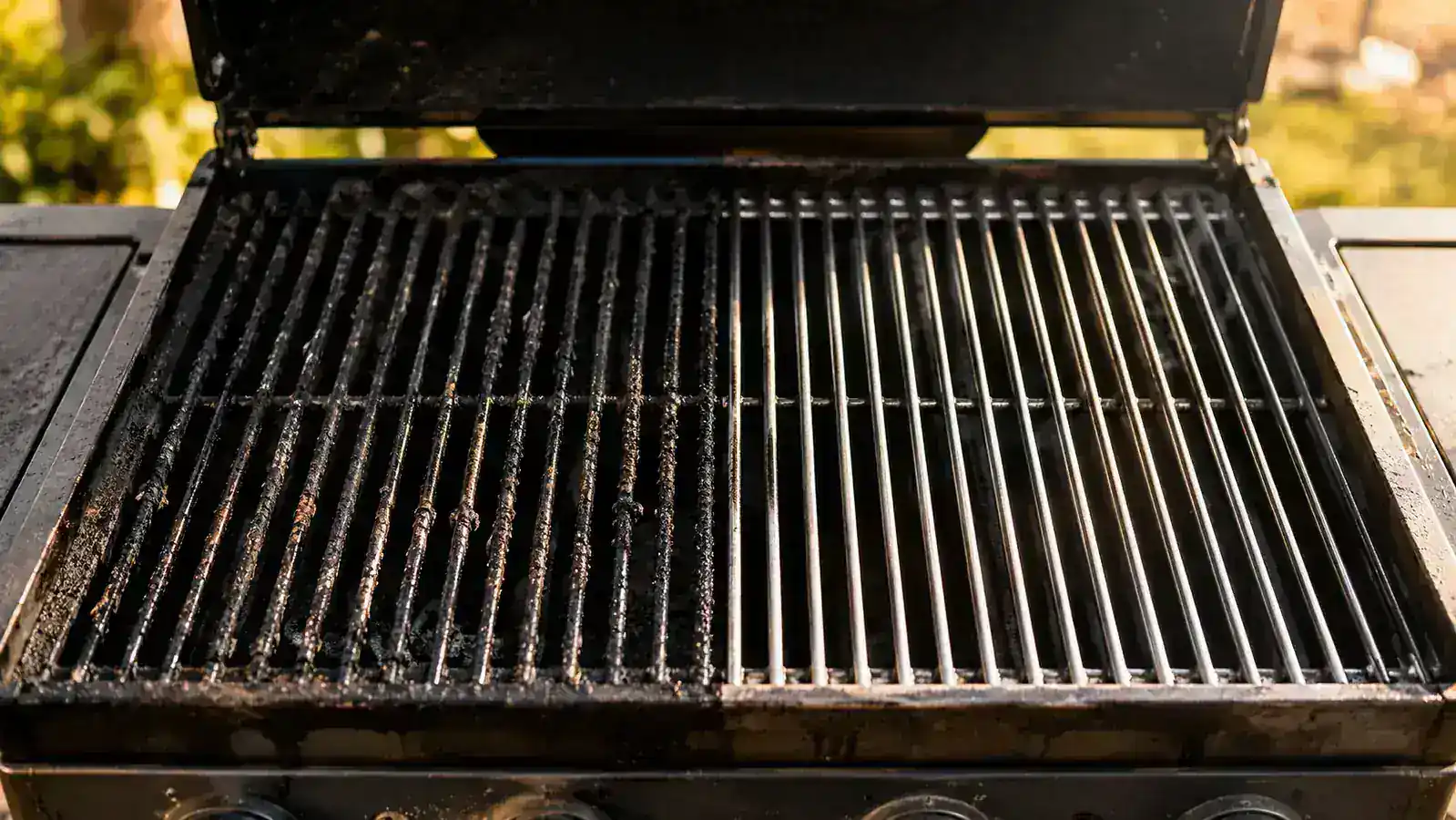 Oiled grill grates gleaming after cleaning, ready for the next cookout with a rack of ribs nearby