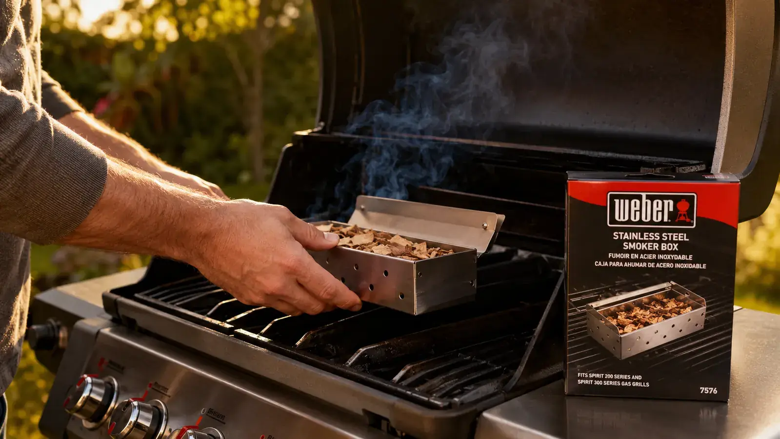 Hands filling a stainless steel smoker box with hickory wood chips over a kitchen counter